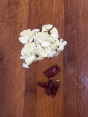 蒜瓣剥皮拍碎，干辣椒切成段儿备用。