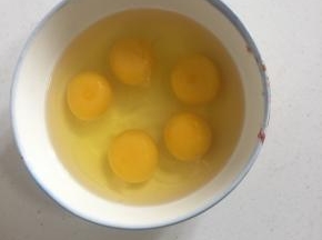 鸡蛋磕入碗中，用筷子打散备用。