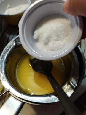 把牛奶跟25g细砂糖加入黄油内，搅拌均匀，让细砂糖完全融化。