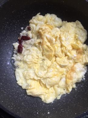 把鸡蛋划散，放入蒜瓣，干辣椒爆香。