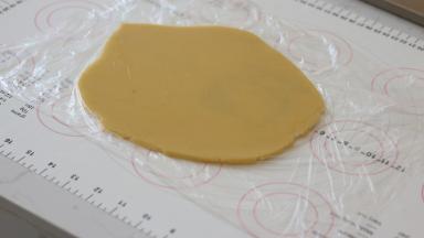 放入保鲜膜内用擀面杖擀成薄厚均匀约3mm厚的面片。然后放入冰箱冷藏松弛30分钟