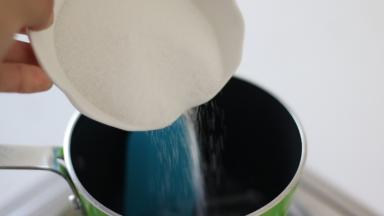 不粘锅中倒入葡萄糖浆，小火加热，分4次加入细砂糖，不停搅拌。每次确保砂糖融化后再加入下一次、