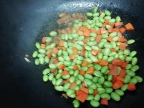 在下入焯好的胡萝卜和毛豆翻炒片刻，即可关火出锅