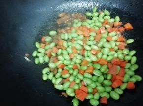 在下入焯好的胡萝卜和毛豆翻炒片刻，即可关火出锅