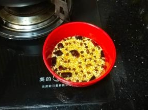 将油慢慢倒入有白芝麻和辣椒粉的碗里拌均匀