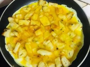 轻轻的转动平底锅，使蛋液均匀的铺在锅底。