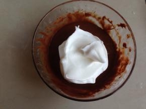 将1/3打发好的蛋白霜加入到蛋黄可可糊里，用刮刀从底部向上翻拌均匀，不要划圈