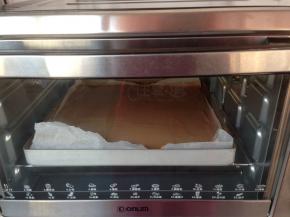 拌好的蛋糕糊倒入铺了油纸的正方形烤盘里，放入已经提前预热到180度烤箱，烘烤18分钟左右（烘烤温度仅供参考）