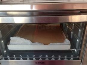 拌好的蛋糕糊倒入铺了油纸的正方形烤盘里，放入已经提前预热到180度烤箱，烘烤18分钟左右（烘烤温度仅供参考）