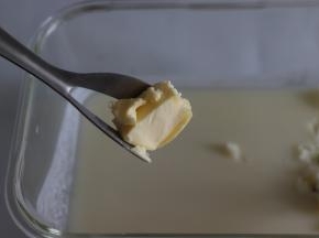 加入黄油，趁热融进去，这步先用勺子或其他工具，铲起，摁压让油融入到冰皮中，稍微等一会，再戴好防粘手套，揉匀，黄油完全的融进去了。这步注意防烫。