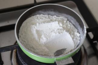 取少量的糯米粉，炒制到稍微发黄， 作为一会要用到的手粉。