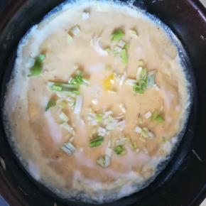 小火锅中滴少许油，倒入面糊抹平，打个鸡蛋，撒上葱花