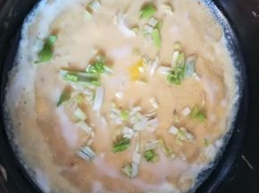 小火锅中滴少许油，倒入面糊抹平，打个鸡蛋，撒上葱花