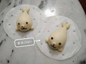 把大圆小圆抹水装上去。可可面团搓出眼睛，鼻头，小嘴。
用少许的红曲粉稀释一下，用毛刷轻刷出腮红。
夏天室温发半小时，冬天烤箱30度发酵半小时，蒸十分钟。