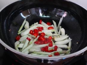 用煎鸭的油，倒入荞头菜、红辣椒，爆炒八成熟；