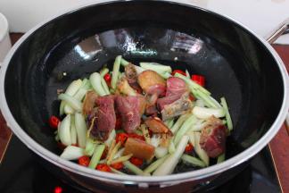 煎好的鸭腿加入，加生抽、辣椒；