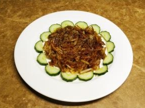 炸好的土豆丝码入盘中，青瓜切片摆盘