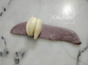 擀平，把黑面片切出合适包裹白色面瓣大小。卷起来，就可以。