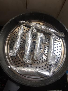 锅里加入适量的水烧开，把卷好的香肠放进蒸锅中。