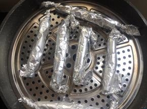 锅里加入适量的水烧开，把卷好的香肠放进蒸锅中。
