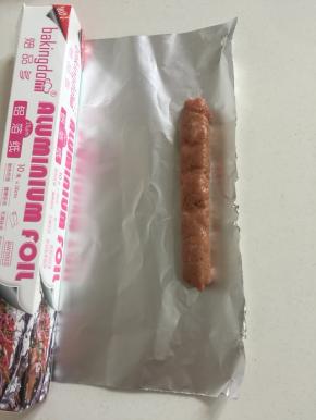 挤好肉糜后，把锡纸根据香肠的大小裁下来。（尽量要把锡纸剪裁的大一点儿，是锡纸能够把香肠全部包裹住。）