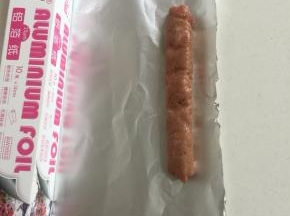 挤好肉糜后，把锡纸根据香肠的大小裁下来。（尽量要把锡纸剪裁的大一点儿，是锡纸能够把香肠全部包裹住。）