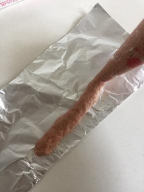 把肉糜装进裱花袋中，前端剪一个小口，把肉糜挤在锡纸上。（香肠的长短随自己的喜好来决定）