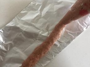 把肉糜装进裱花袋中，前端剪一个小口，把肉糜挤在锡纸上。（香肠的长短随自己的喜好来决定）