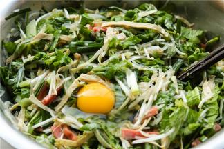 先加入一颗鸡蛋，但不要搅拌。等到待会面胚做好之后开始做饼时候搅拌均匀。做这个饼，里面的菜不用切得太碎，更好操作。