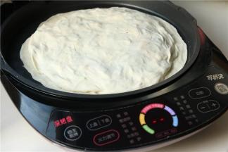 预热完成会有提示音，然后放入刚才做好的饼胚，开始烙饼。电饼铛是烙饼神器，饼皮焦脆而且不会糊，也不用看管。记得小时候妈妈做菜馍时候要一直看着，不小心就会糊了。