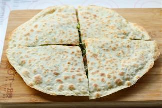 烙的表面焦黄的菜馍，平均切成4份，愉快的开始吃吧。