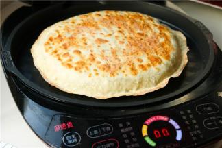 盖上电饼铛盖子，定时5分钟即可。最后饼皮焦黄，烙馍就做好了。