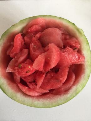 用勺子把西瓜果肉挖出来一半，一半留在西瓜里。（要不然太满，一会儿打西瓜汁儿的时候会溅出来。）