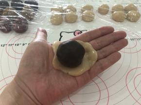 7、取一个面团按扁，中间放入一个月饼馅料。