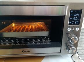 骨肉相连放入预热好的烤箱中下层，上下火180度烤20分钟，中途暂停取出烤盘给骨肉相连翻面继续烤