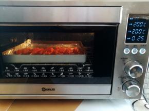 新奥尔良鸡胸肉串放入烤箱中下层，上下火200度烤25分钟，中途暂停取出烤盘翻面继续烤，前面烤过香肠，烤箱不需要再预热了。