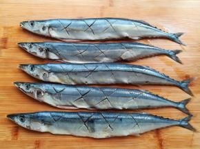 秋刀鱼解冻后，去掉鱼鳃，内脏和黑色的软膜，用厨房纸擦干鱼身，在鱼的两面各打4个花刀，这样腌制的时候容易入味。鱼身上有蓝色的小点，是秋刀鱼的鳞片。