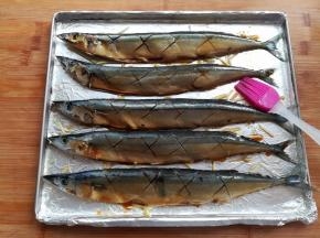 在秋刀鱼身的另一侧也刷上适量的腌料汁