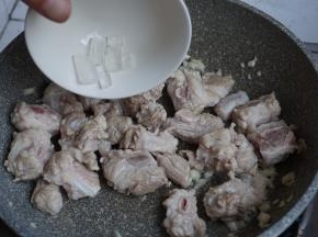 加入料酒，翻炒片刻，倒入冰糖，炒至变色