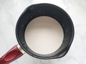 先来制作卡士达奶油。把牛奶倒入奶锅中加热至即将沸腾，离火待凉。