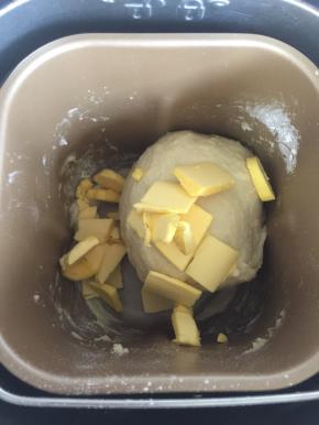 加入提前软化的黄油，继续启动面包机揉面程序揉面25分钟左右。