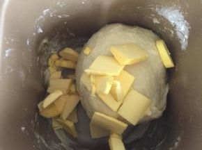 加入提前软化的黄油，继续启动面包机揉面程序揉面25分钟左右。