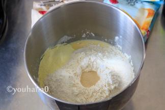 将放凉的汤种与鸡蛋、牛奶等所有的材料（黄油、盐除外），放入搅拌缸中，酵母放在面粉的最上面。