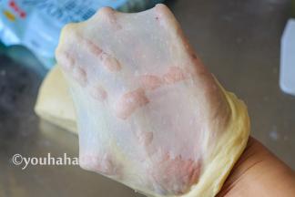 继续用中速搅打十分钟后，取出面团至案板上，面团比较黏手，在案板上摔打几下，取一块小面团，双手轻轻拉开，拉开成手套膜，很薄很有韧性。金龙鱼面包用小麦粉出手套膜的效果很棒，平时打面差不多要半个小时，这个20分钟就可以了。