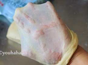 继续用中速搅打十分钟后，取出面团至案板上，面团比较黏手，在案板上摔打几下，取一块小面团，双手轻轻拉开，拉开成手套膜，很薄很有韧性。金龙鱼面包用小麦粉出手套膜的效果很棒，平时打面差不多要半个小时，这个20分钟就可以了。