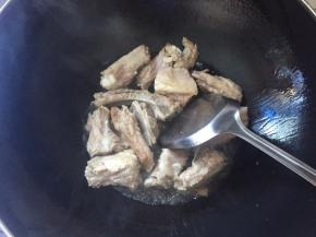 锅中倒入食用油，烧至7成熟，将排骨倒进去翻炒，油不要太多，因为排骨也会炼出油来，放入两片生姜