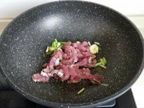 起油锅，加入葱姜蒜炒香，再加入肉丝煸炒。