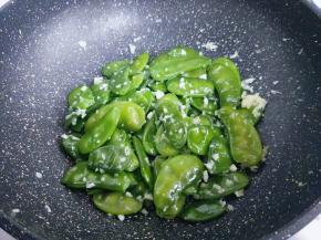 锅中加入橄榄油，油温7成加姜蒜炒香，再加入焯水的扁豆，炒至扁豆打皱时加入盐翻炒。
