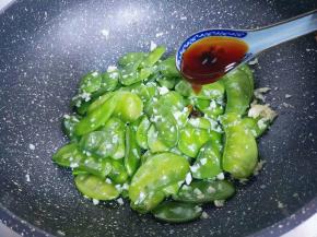 加入十三香，再加入蚝油，生抽，盖上盖子将扁豆炒熟。