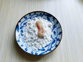 将腌制好的鱿鱼圈放入淀粉中，裹满淀粉。